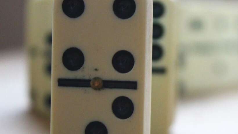 Dominoes, symbolising preventing collateral damage or consequences.