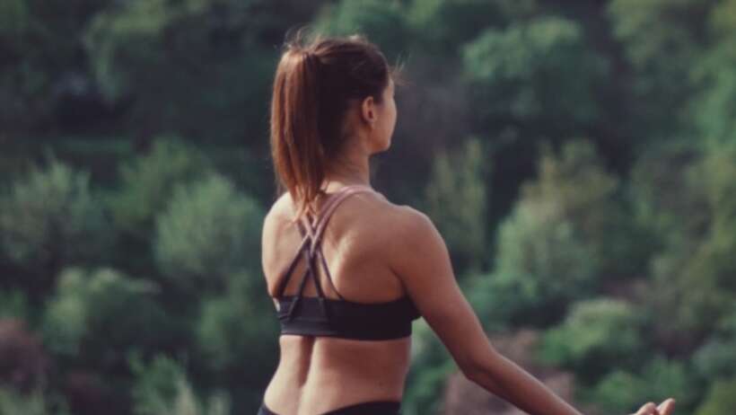 Woman meditating outdoors for mindfulness and relaxation.