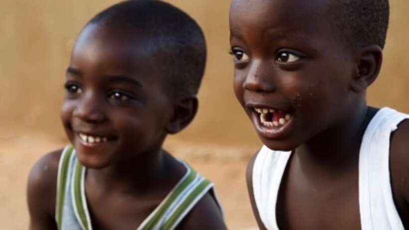 Two young African boys smiling.