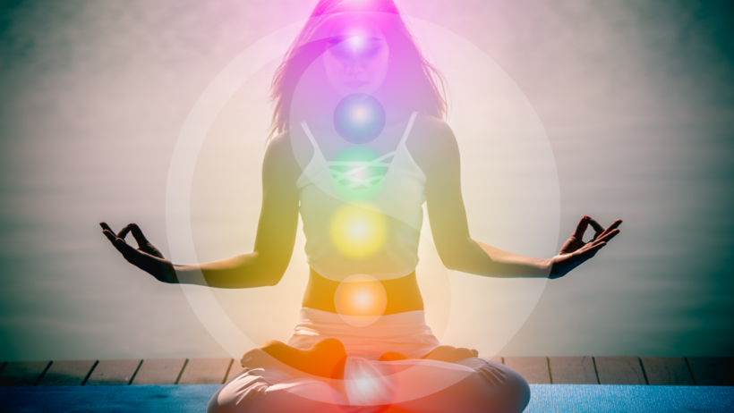 Woman meditating with chakra points highlighted.