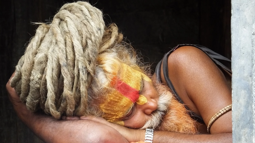 Sleeping Sadhu with painted face and dreadlocks